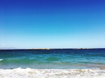 Scenic view of sea against clear blue sky