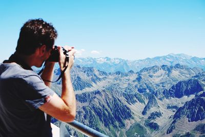 Man photographing mountains against sky at pic du midi de bigorre