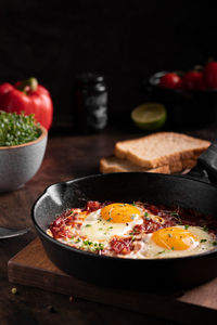 Israel traditional food shakshouka with micro greens in a cast-iron pan