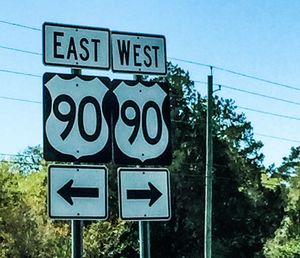 Low angle view of signboard against blue sky