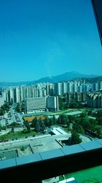 View of cityscape against clear blue sky