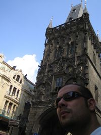 Low angle portrait of young man against building against sky