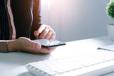 Midsection of man using mobile phone on table