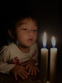 Close-up of cute baby girl in the dark