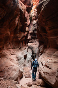 Rear view of man walking in cave