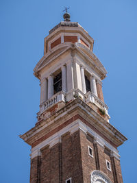 Low angle view of clock tower against clear blue sky