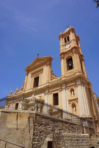 Low angle view of historic building against blue sky