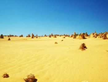 Scenic view of desert against clear blue sky