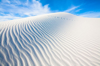 Sand dunes in desert against sky