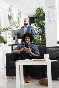 Young woman using laptop while sitting on table