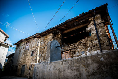 Low angle view of old building against clear blue sky