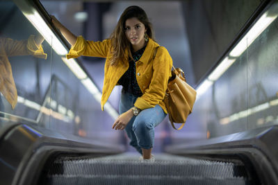 Portrait of young woman on escalator