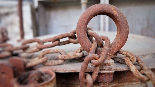Chain on rusty metallic mooring ring