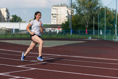 Full length of woman exercising on field