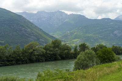 Scenic view of river and mountains against sky