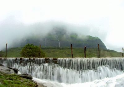 Scenic view of waterfall against sky