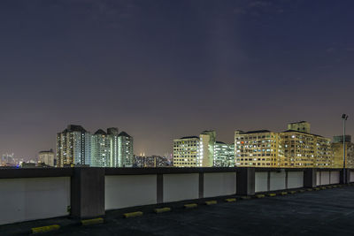 Illuminated buildings against sky at night