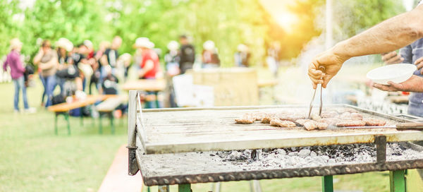 Close-up of man preparing food on grill 