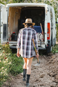 Rear view of woman standing at farm