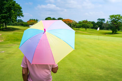 Rear view of woman holding umbrella