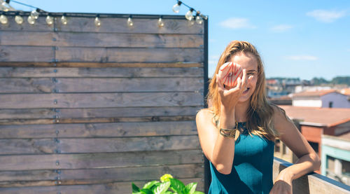 Woman holding doughnut in front of face