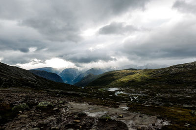 Scenic view of mountains against cloudy sky