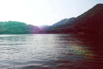 Scenic view of lake by mountains against sky