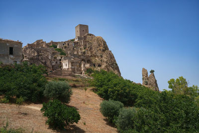 Low angle view of old ruins against clear blue sky