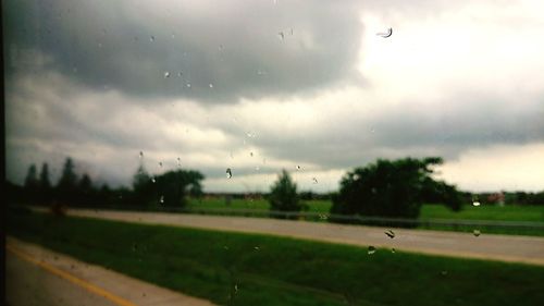 Raindrops on road seen through wet window