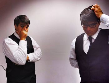 Young man looking away against wall