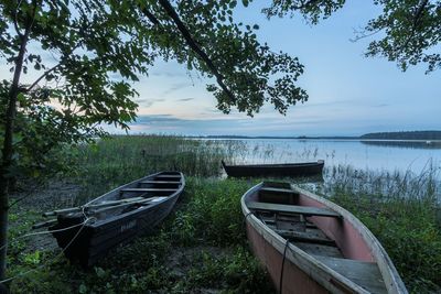 Boats moored on lake against sky