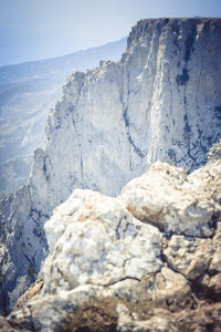 Close-up of rocks on snowcapped mountain against sky