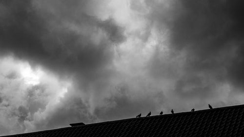 Low angle view of silhouette roof against sky