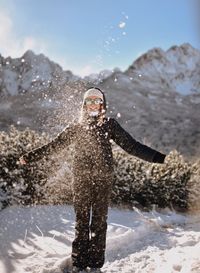 Woman paying with snow on during winter outdoors