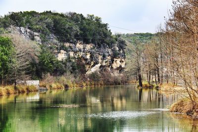 Scenic view of lake by trees against sky