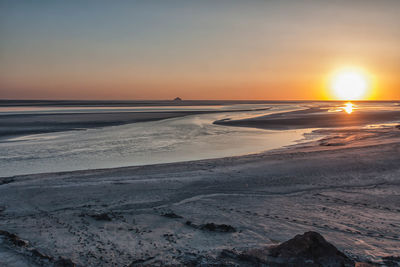 Scenic view of beach against sky during sunset