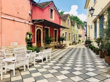 Potted plants on sidewalk cafe by buildings in city