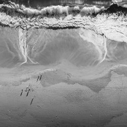 Aerial view of waves rushing towards shore