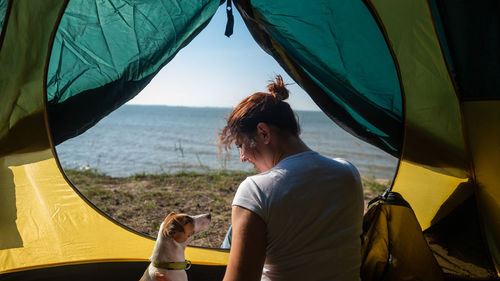 Rear view of woman with dog on beach