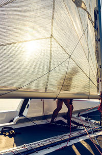 Low section of person on sailboat against sea