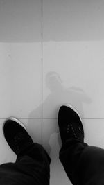 Low section of person standing on tiled floor