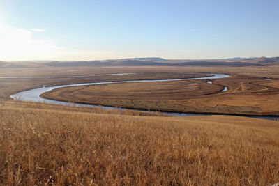 The quiet winding river is flanked by beautiful yellow prairie