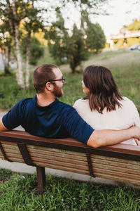 Rear view of couple sitting on bench