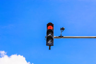 Low angle view of road sign against clear blue sky