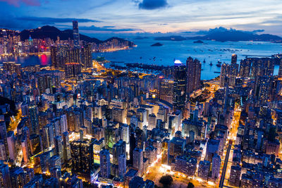 Aerial view of buildings in city against sky at dusk