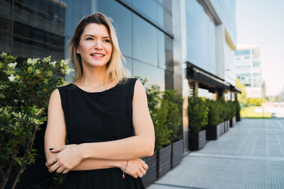 Portrait of smiling young woman standing outdoors