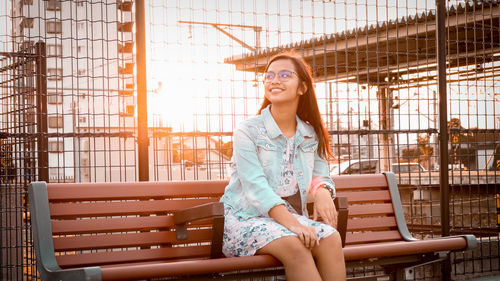 Portrait of smiling young woman sitting outdoors