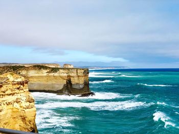 Rock formation in sea against sky