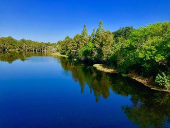 Scenic view of lake against clear blue sky