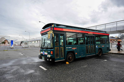 Bus on city street against sky